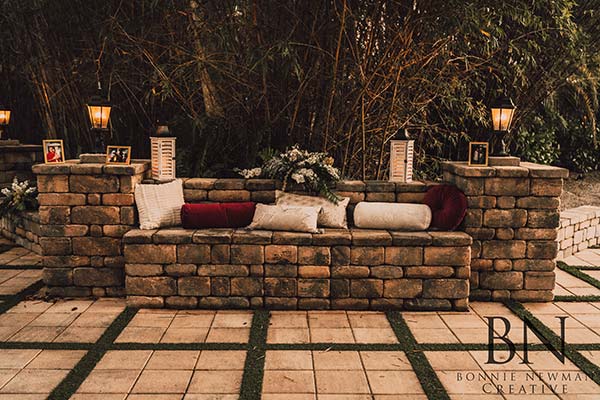 outdoor seating area decorated with lanterns, pillows and flowers
