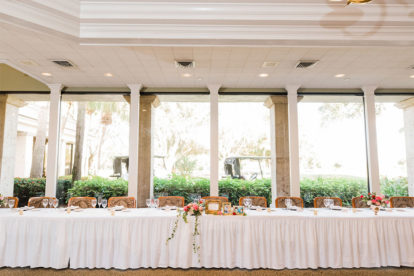 head table at a wedding reception venue with large windows