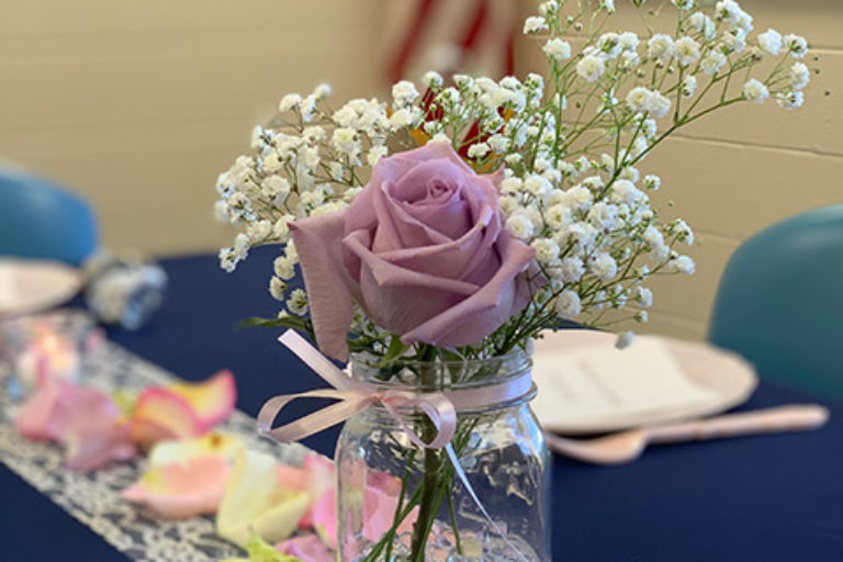Purple rose with Baby's Breath and table runner with flower petals