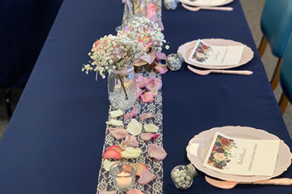 Bridal shower place settings and table runner with flowers and petals