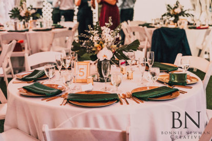 table at a wedding reception with gold and emerald green accents