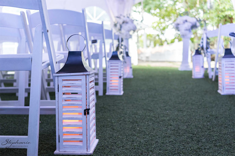 white rustic lanterns lining the aisle for a wedding ceremony
