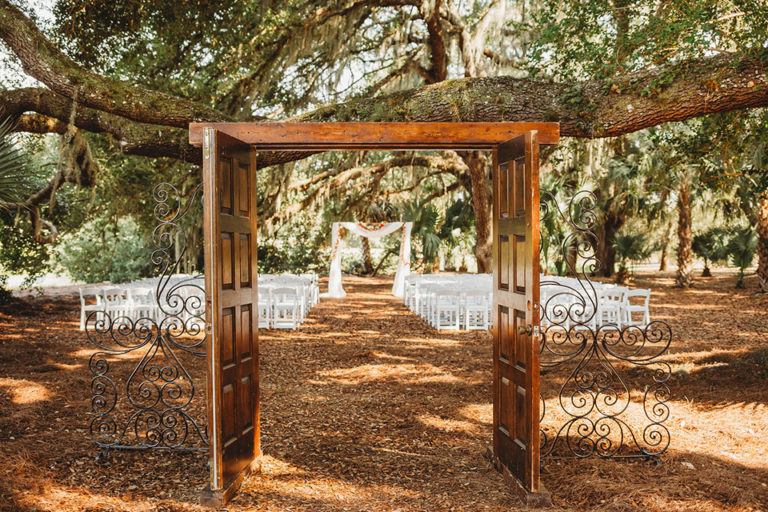 Fort Myers Wedding - ceremony site under a tree with double doors leading to the arch