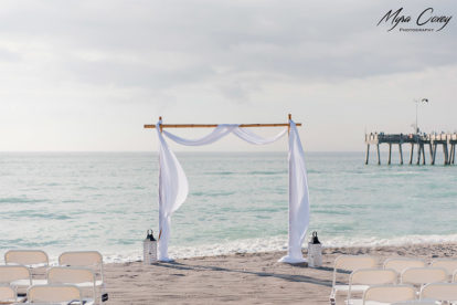 bamboo arbor and chairs for wedding ceremony on the beach with Venice Fishing Pier in the background