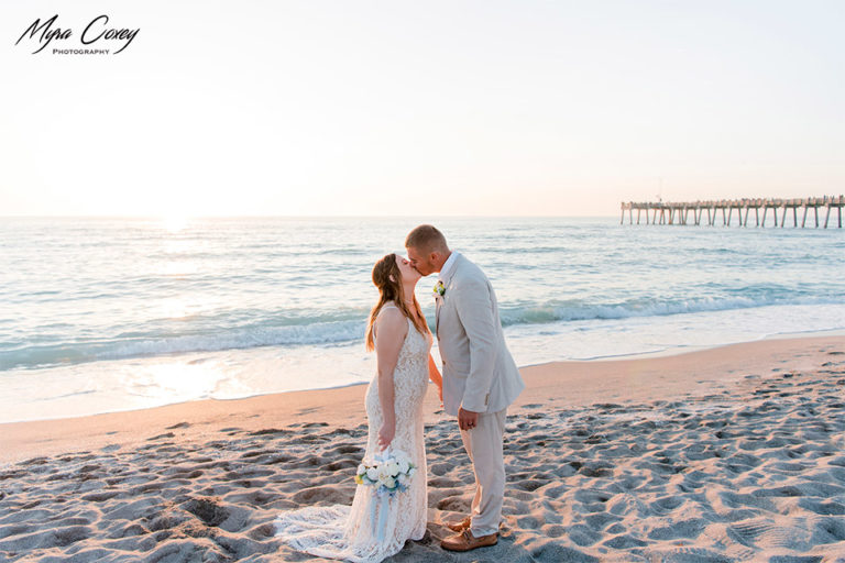 bride and groom kissing on the beach with the Venice Fishing Pier in the background