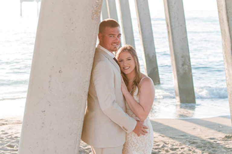 bride and groom standing under the Venice Fishing Pier