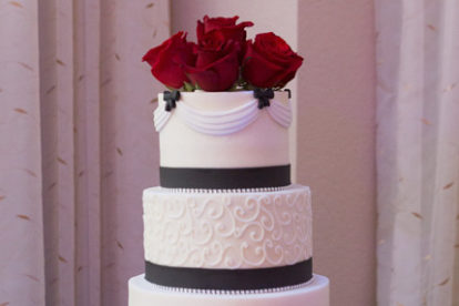 beautiful black and white Wedding Cake with red rose topper at an Orlando resort wedding