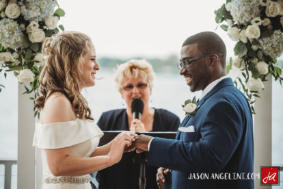 bride and groom exchanging rings at riverside wedding ceremony