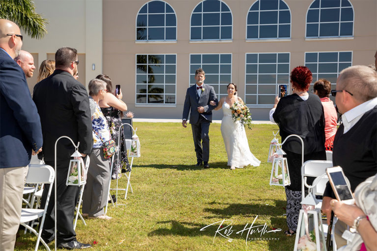 father walking bride down the aisle at an outdoor wedding ceremony on Charlotte Harbor in Gunta Gorda, FL