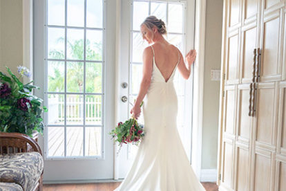 bride posing in a doorway with the train of her gown spread