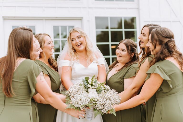 bride surrounded by bridesmaids in sage green dresses