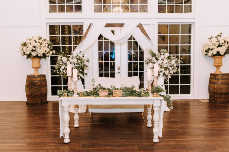 white sweetheart table decorated with candles, flowers, and vines at a wedding reception in Seffner, FL