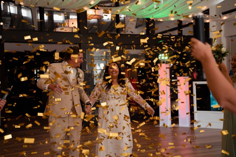 bride and groom in a shower of gold confetti