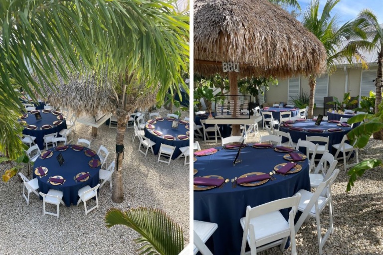 Englewood Florida outdoor wedding reception decor - round tables with navy tablecloths, gold chargers, and purple napkins, with tiki hut and palm trees