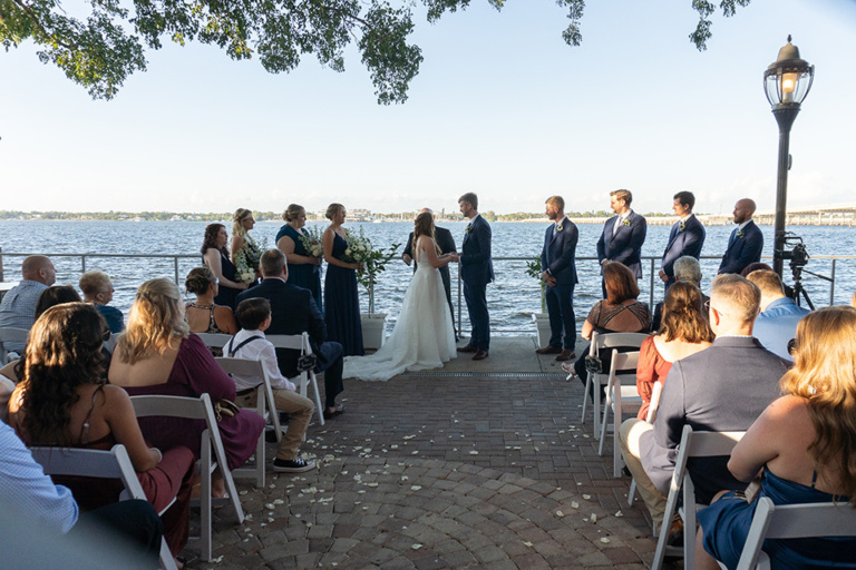 an outdoor wedding ceremony overlooking the water