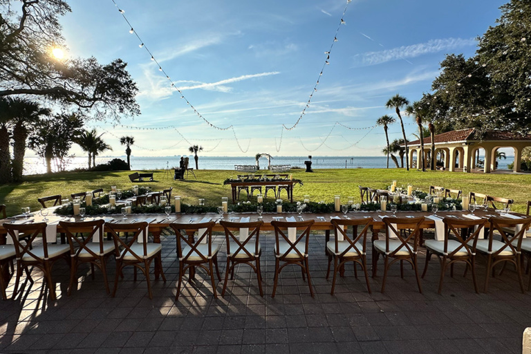 outdoor wedding reception - long wooden table with a view of the water