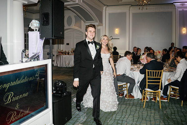 bride and groom enter a ballroom