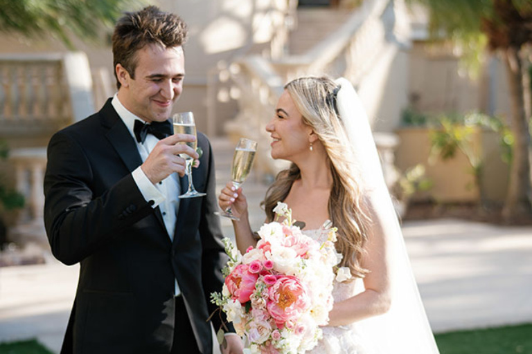 bride and groom smiling and sipping champagne at the Ritz-Carlton in Sarasota